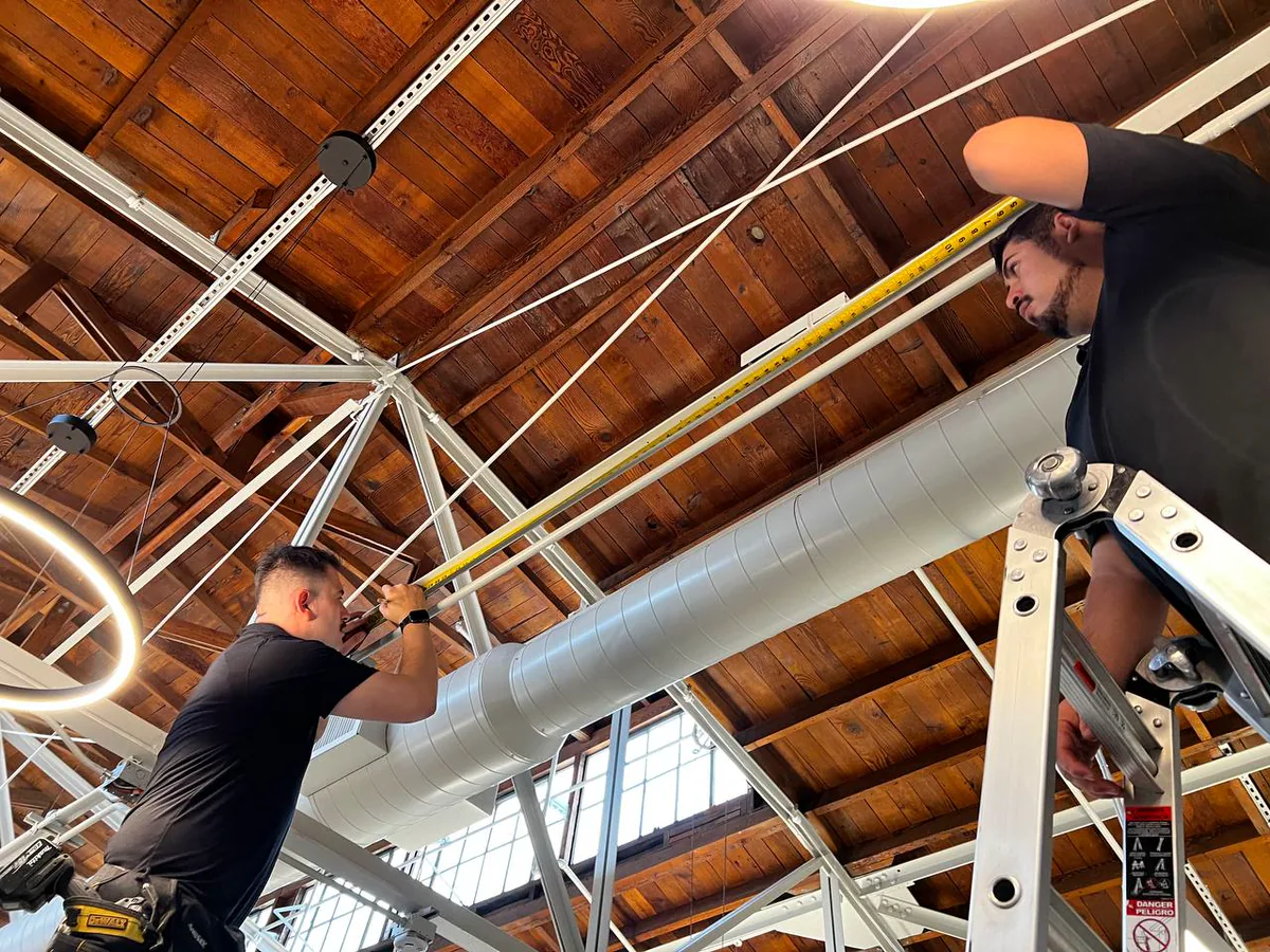 Alro team measuring a commercial window treatment opening