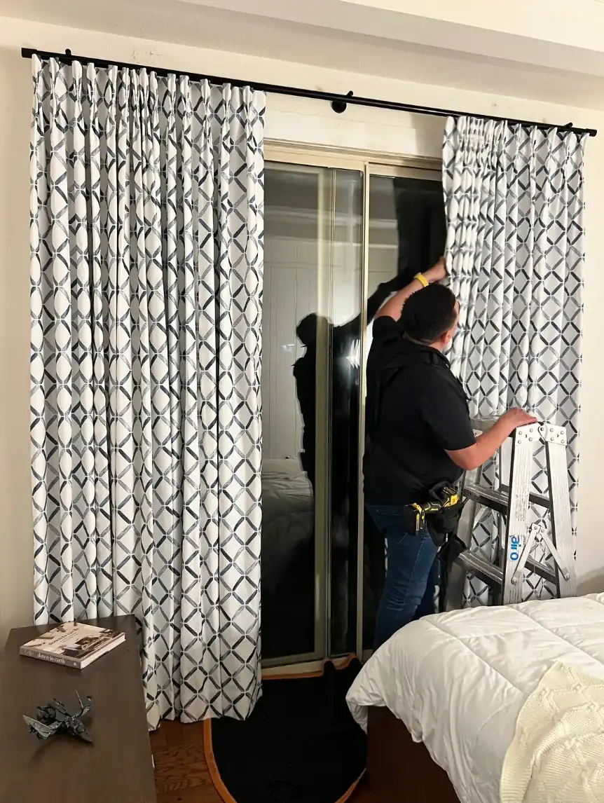 Alro installer fitting custom drapery at a residential window