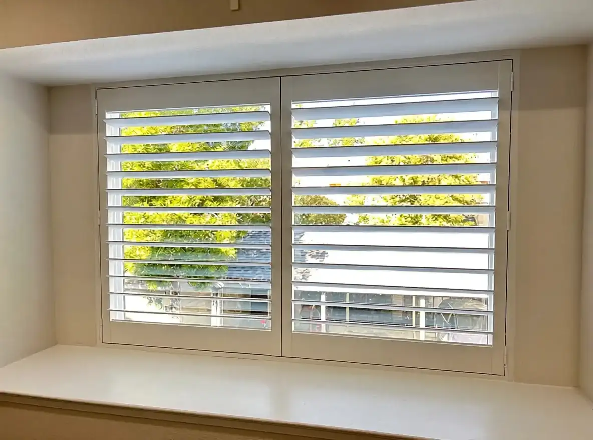 Interior shutters filtering a bright residential window