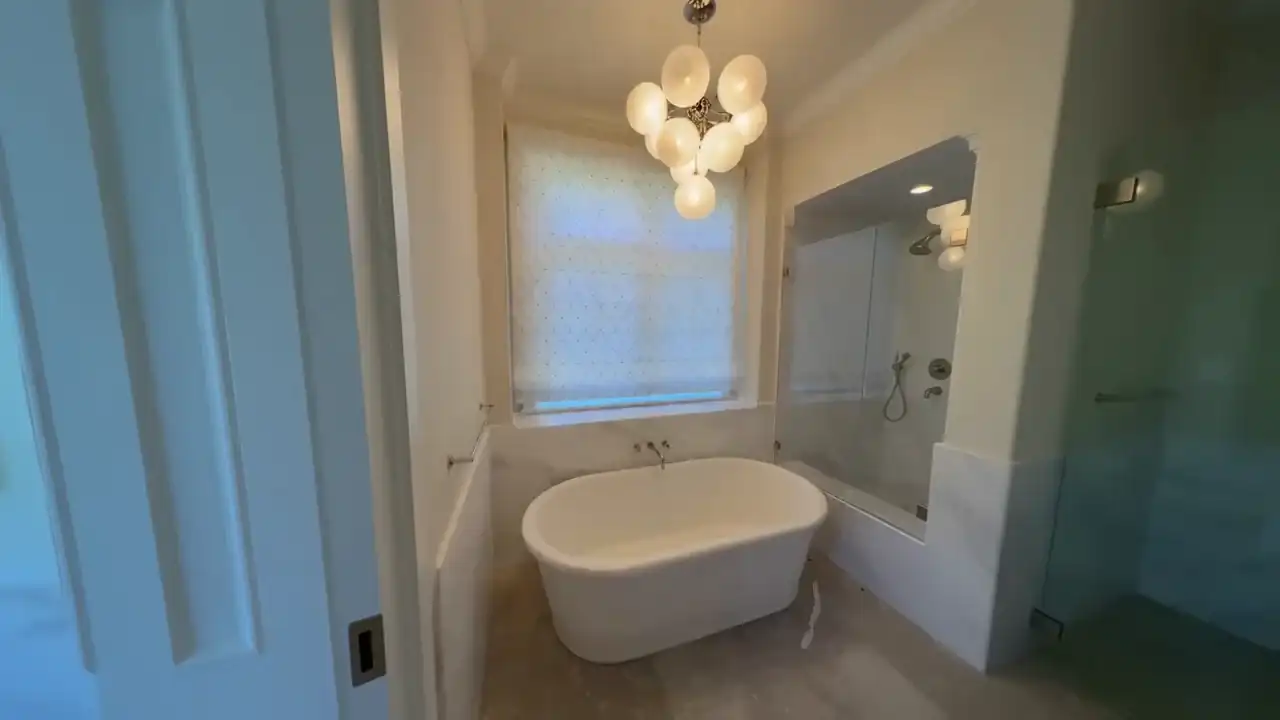 Motorized roller shade installed above a soaking tub